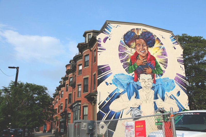 Mural of kid in color on shoulders of kid in black and white