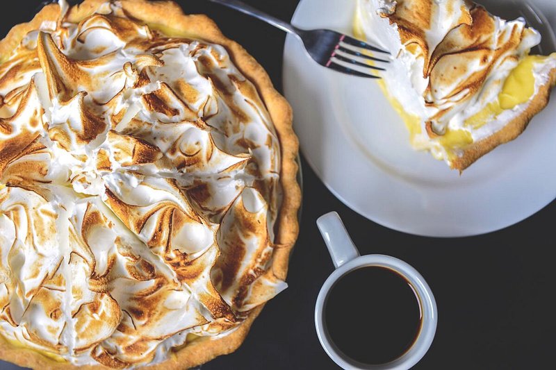 Lemon meringue pie next to slice of pie