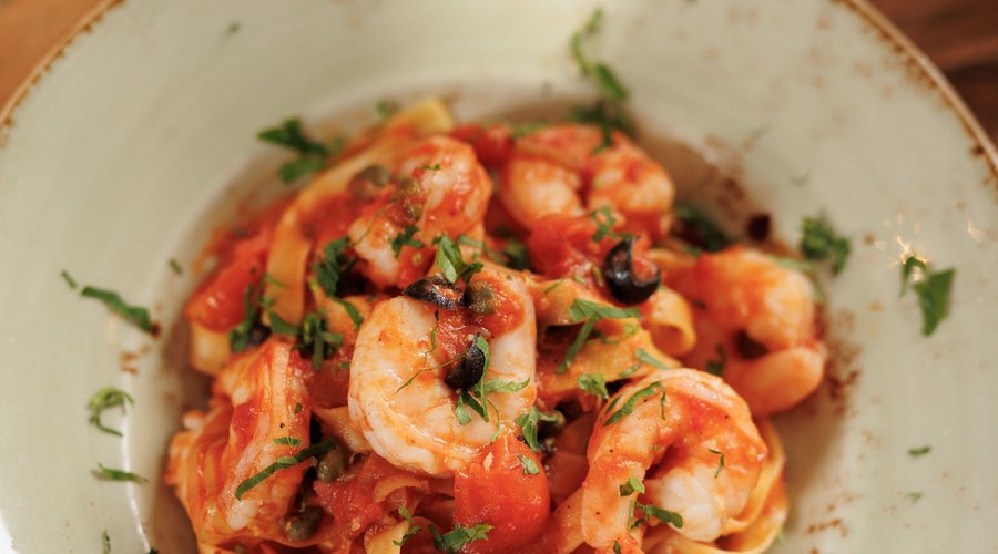 Tagliatelle scampi. Tagliatelle tossed with fresh scampi, leeks, cherry tomatoes, garlic, capers and olives. Topped with parsley