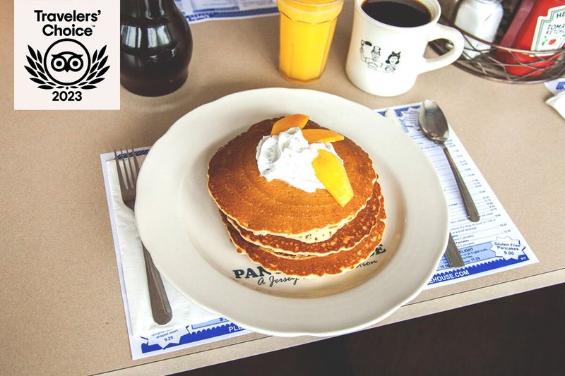 Stack of pancakes topped with whipped cream