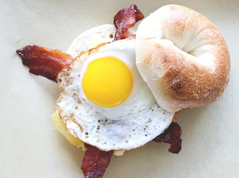 Bagel with cheese, bacon, and fried egg