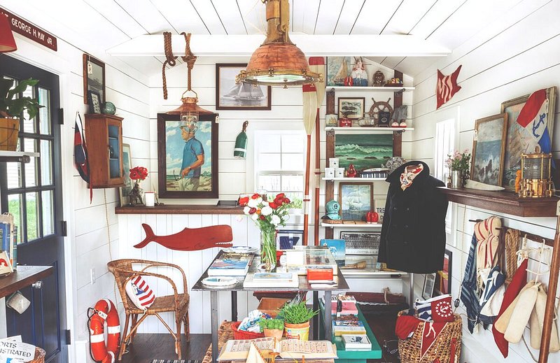 Shop with white wooden walls and a lot of red and blue nautical-themed items