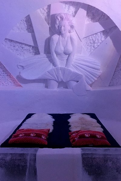 An intricate ice carving of Marilyn Monroe above a bed in Snowhotel Kirkenses, Norway