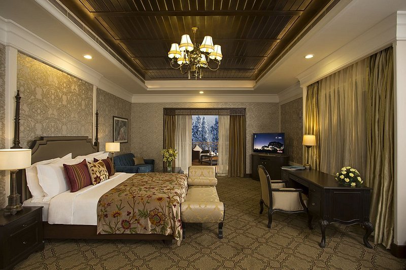 A bedroom with high ceilings and lavish furniture in a cottage at The Khyber Himalayan Resort & Spa
