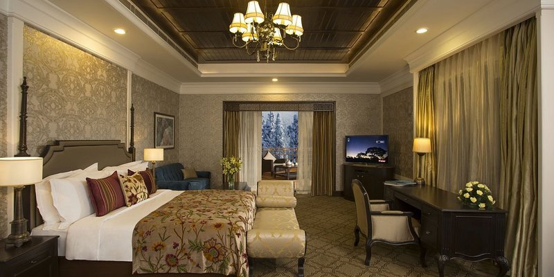 A bedroom with high ceilings and lavish furniture in a cottage at The Khyber Himalayan Resort & Spa.