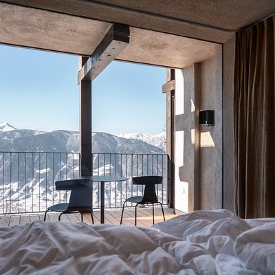 Interior of a comfy room with a private patio and sweeping mountain views at Miramonti Boutique Hotel.