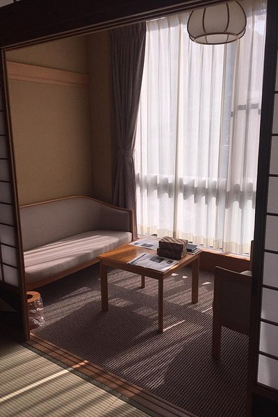 아늑한 좌석 공간과 부드러운 조명이 있는 료칸 사카야의 객실 내부