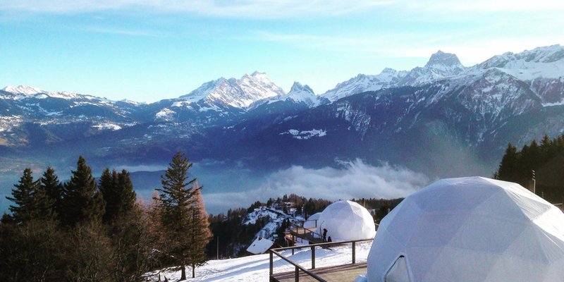 Exterior view of the chic pods at Whitepod Original, an eco-luxury hotel built on a slope in the Swiss Alps.