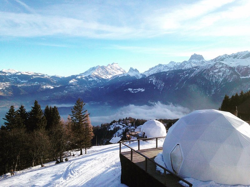 Εξωτερική άποψη των κομψών διαμερισμάτων στο Whitepod Original, ένα οικολογικό πολυτελές ξενοδοχείο χτισμένο σε πλαγιά στις ελβετικές Άλπεις