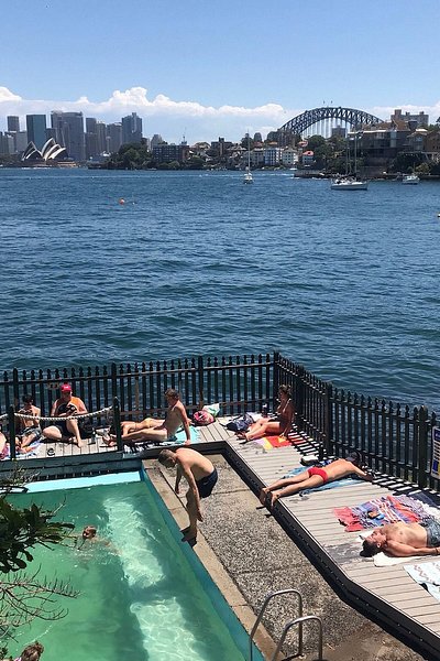 A group of people sunbathing on the deck at Maccallum Seawater Pool