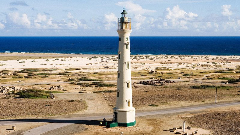 Aerial view of lighthouse overlooking ocean beyond