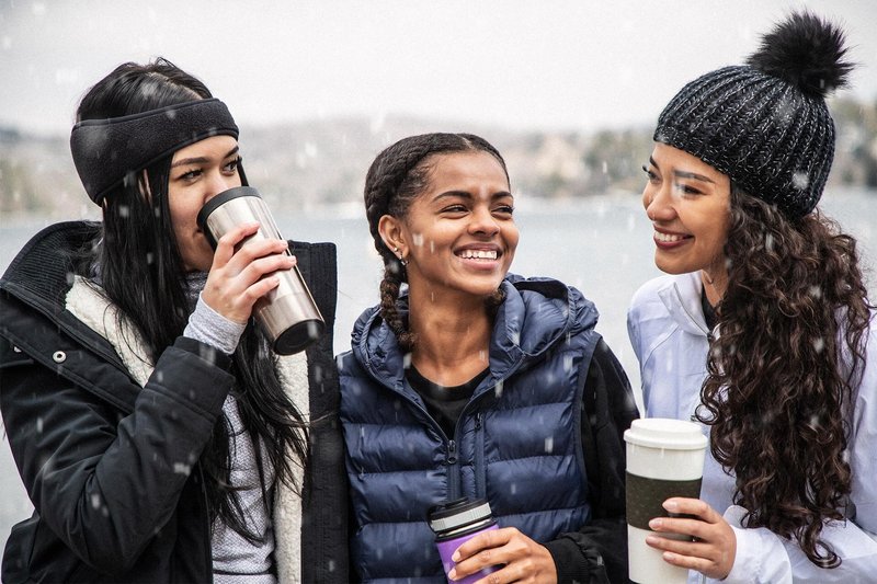 Group of friends enjoying drinks in the snow