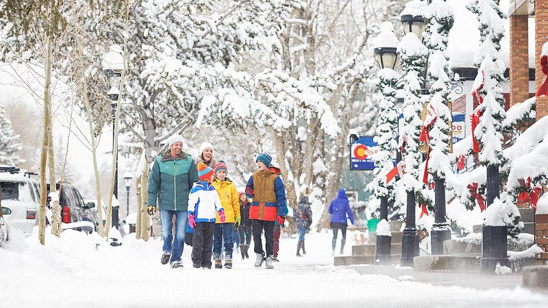 Family walking through snow on main street of Breckenridge, Colorado