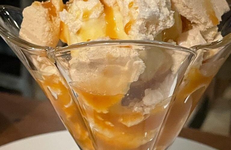 Coppa di gelato alla vaniglia con meringa e salsa al caramello salato