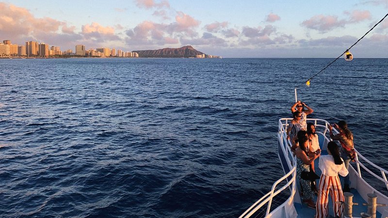 Group of friends aboard sunset boat cruise with Prince Kuhio Tours