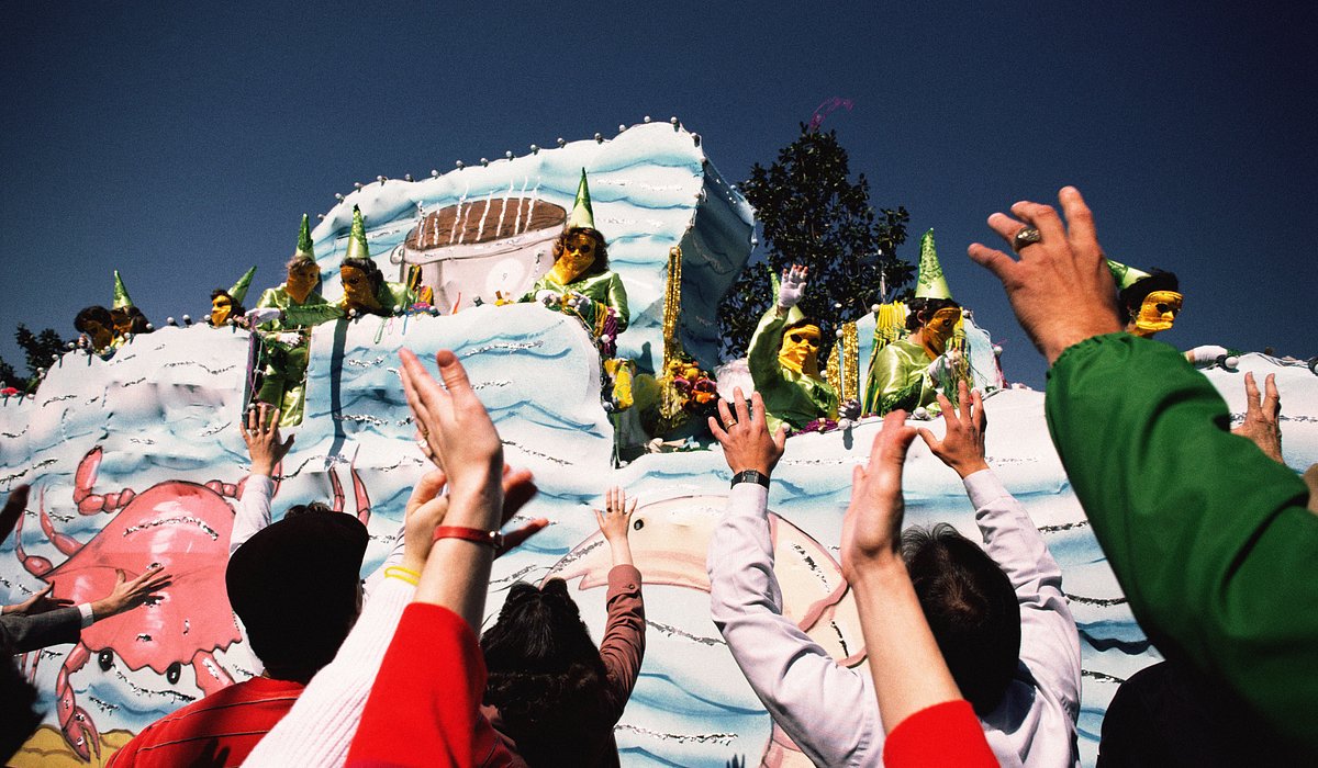 Μια ομάδα ανθρώπων προσπαθεί να πιάσει αντικείμενα από ένα άρμα κατά τον εορτασμό της Λιπαρής Τρίτης στη Νέα Ορλεάνη