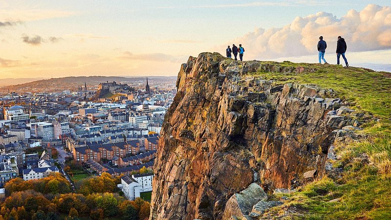 People hiking through Holyrood Park, with view of Edinburgh Castle