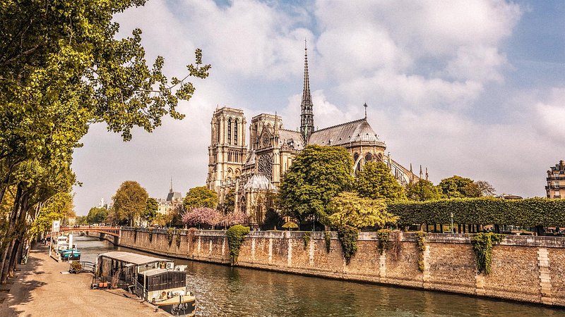 Notre Dame cathedral with houseboats on Seine during springtime in Paris