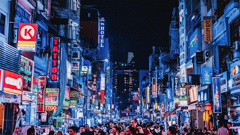 Tourists walking through crowded street in Ho Chi Minh City at night