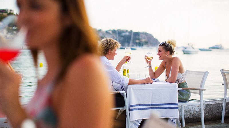 People dining at restaurant in Mallorca, with view of the ocean