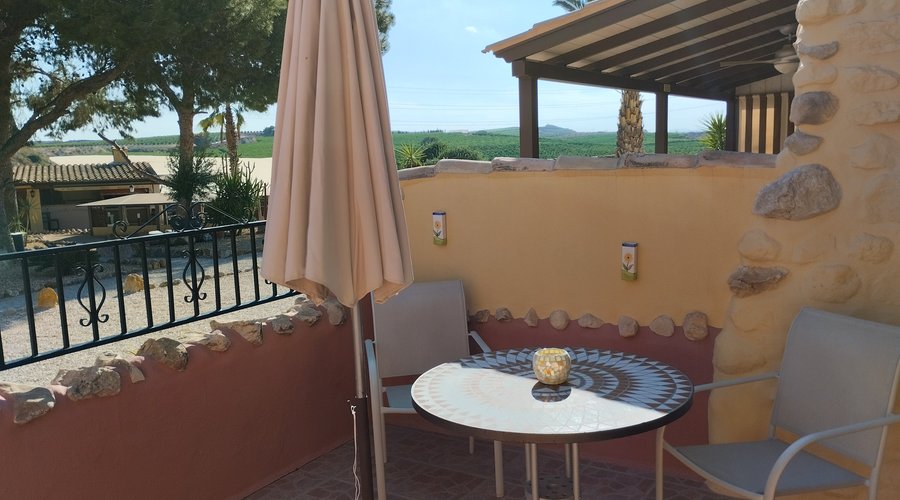 Eigen terras met parasol en zitje.