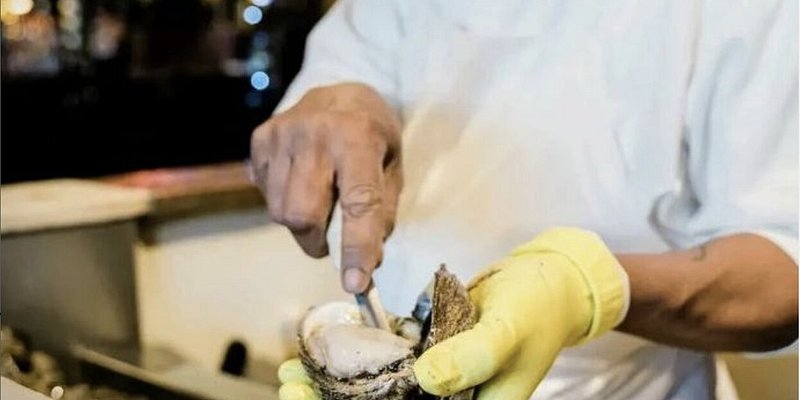 Person shucking oyster