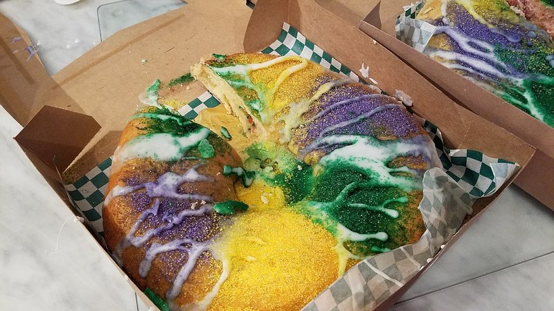 King Cake topped with yellow, green, and purple sprinkles