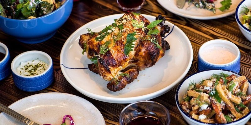 Table topped with several dishes including rotisserie chicken