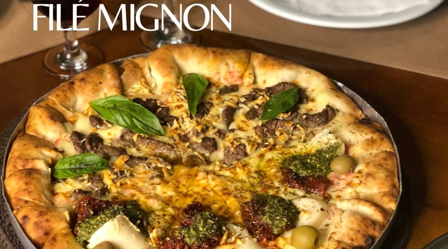 A pizza de filé mignon é super aromática e saborosa, feita com manjericão e queijo parmesão. Nesta foto temos a metade filé mignon e metade rúcula, com borda recheada de mussarela. 