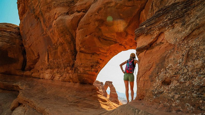 Hiker viewing the Delicate Arch at Arches National Park, Utah