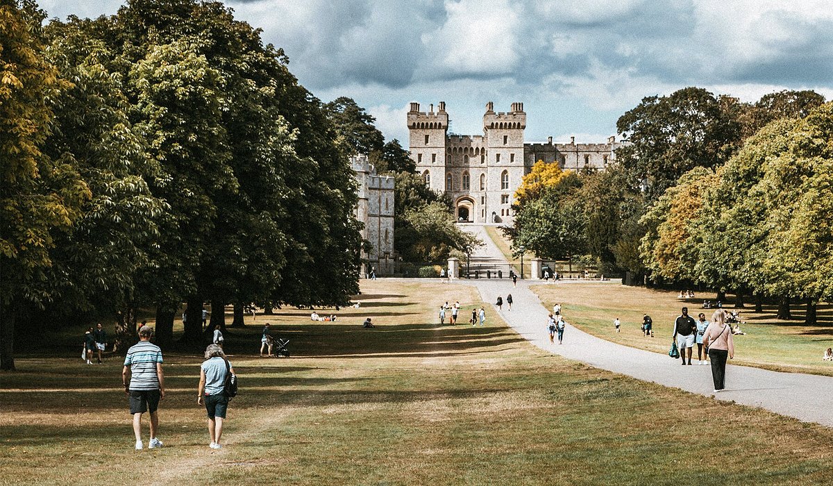 The pathway leading up to Windsor Castle, bordered by lush green grass and trees.