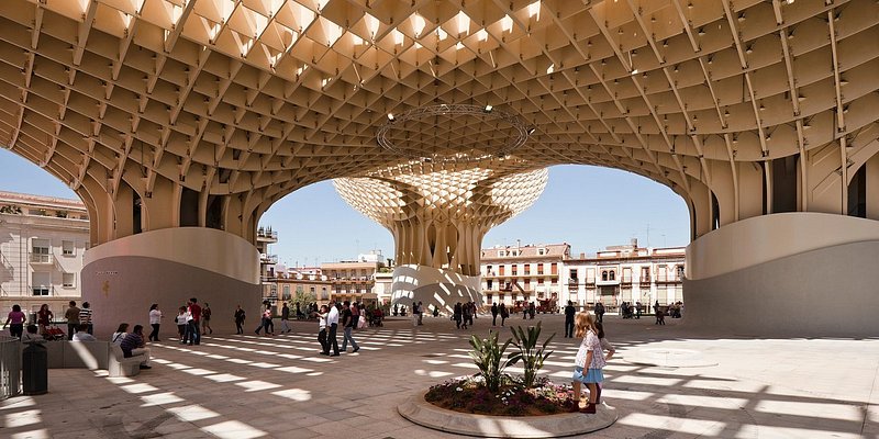 People standing under huge wood structure