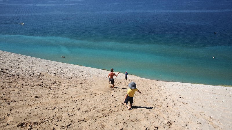 Family running down the dunes at Sleeping Bear Dunes, Empire, Michigan 