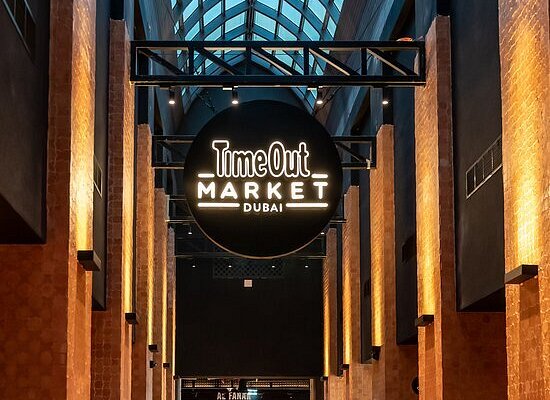 An atrium with a sign for Time Out Market Dubai