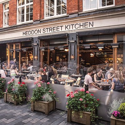 Restaurant terrace with chairs and tables outside a building that read