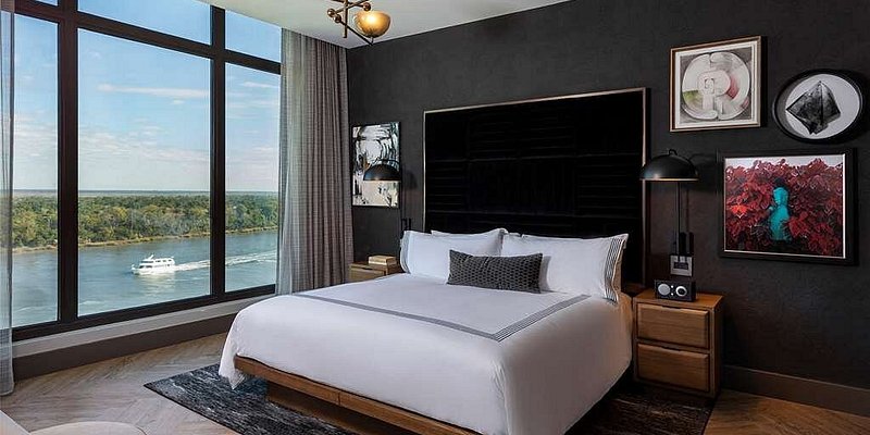 Chic suite with black accent wall and large window overlooking river
