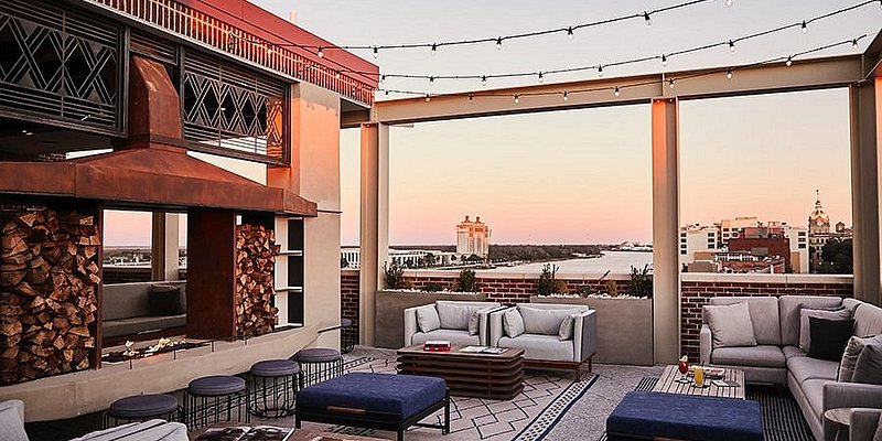 Rooftop space with couches, a fire pit, and view of river