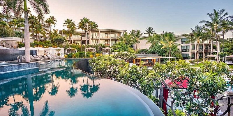 An infinity pool reflecting the palm trees at Andaz Maui At Wailea Resort.