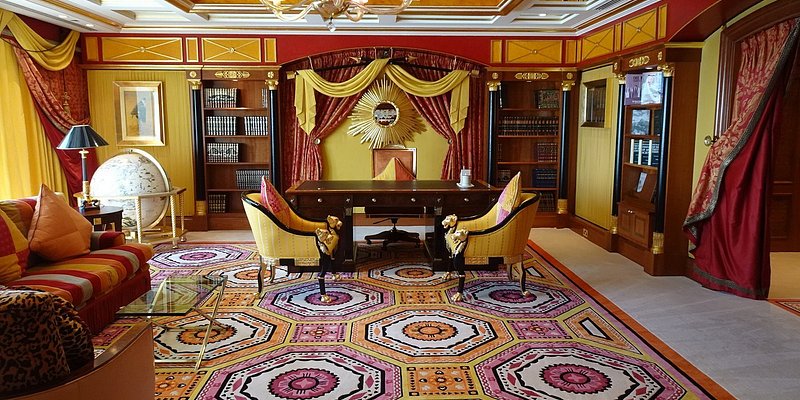 Opulent red and gold room with patterned carpet and drapes