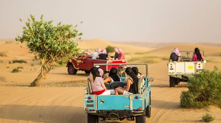 People on land rovers in the desert