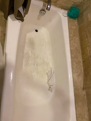 Dirty stained bathtub in our room