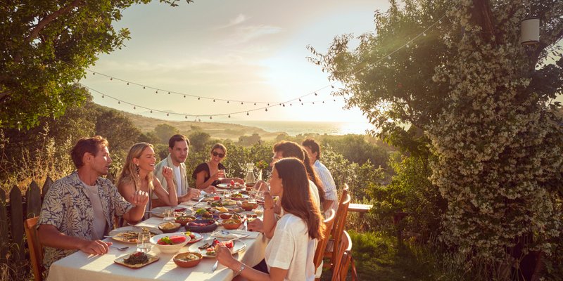 Friends dining outside at sunset