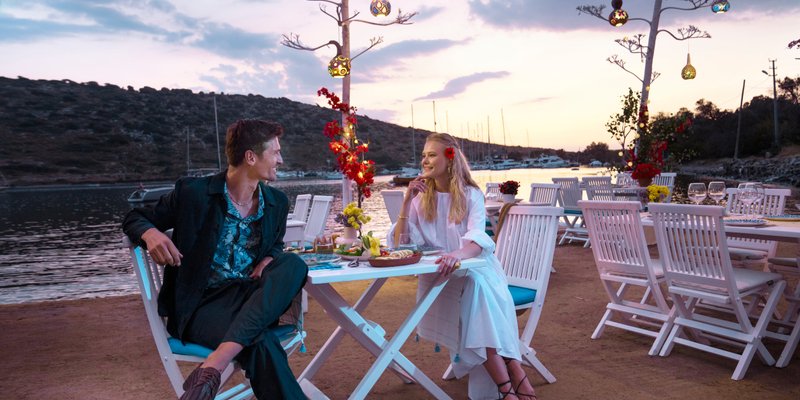 A couple dining outside at sunset