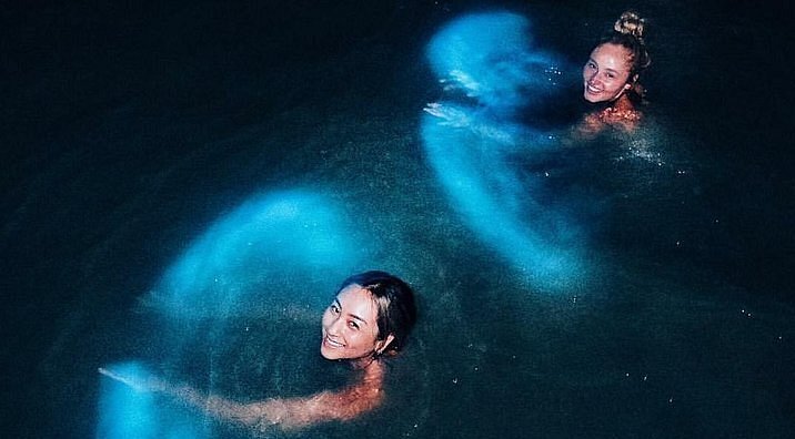 Two people swim in bioluminescent waters at La Parguera