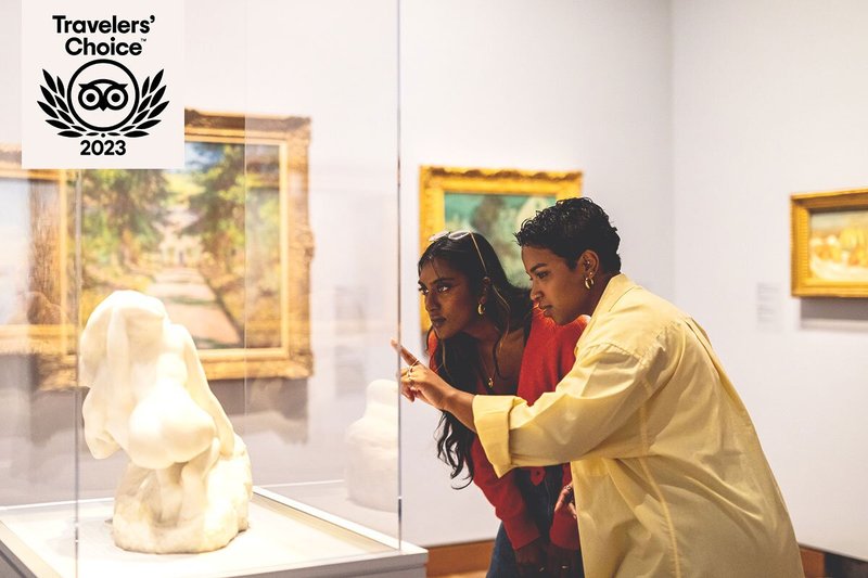 Two people looking at sculpture inside glass box