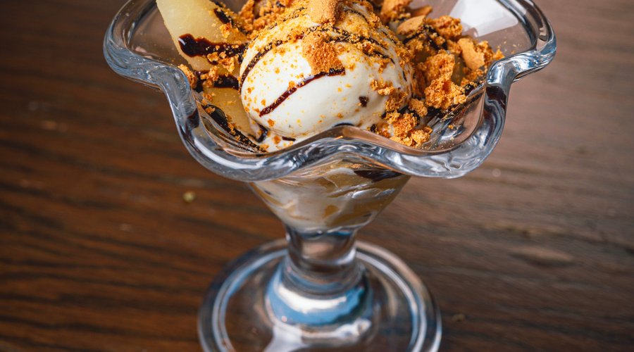 Warm poached pear with vanilla gelato, chocolate sauce & crunchy amaretto 