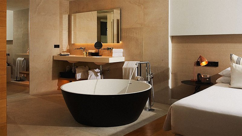 A modern circular soaking tub inside a suite.