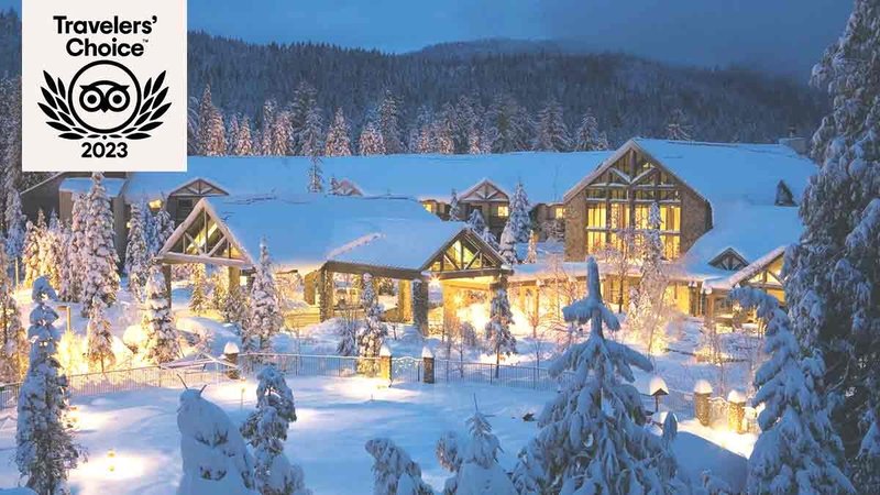 Exterior of snow-covered lodge set amid sow and trees