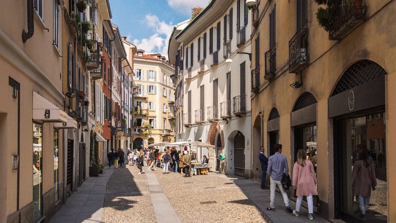 A cobblestone street lined with historic buildings in sunny colors.