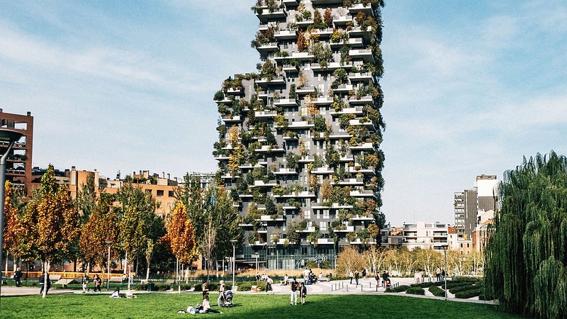 The two towers of the Bosco verticale buildings with vegetation covering the sides and balcony spaces.